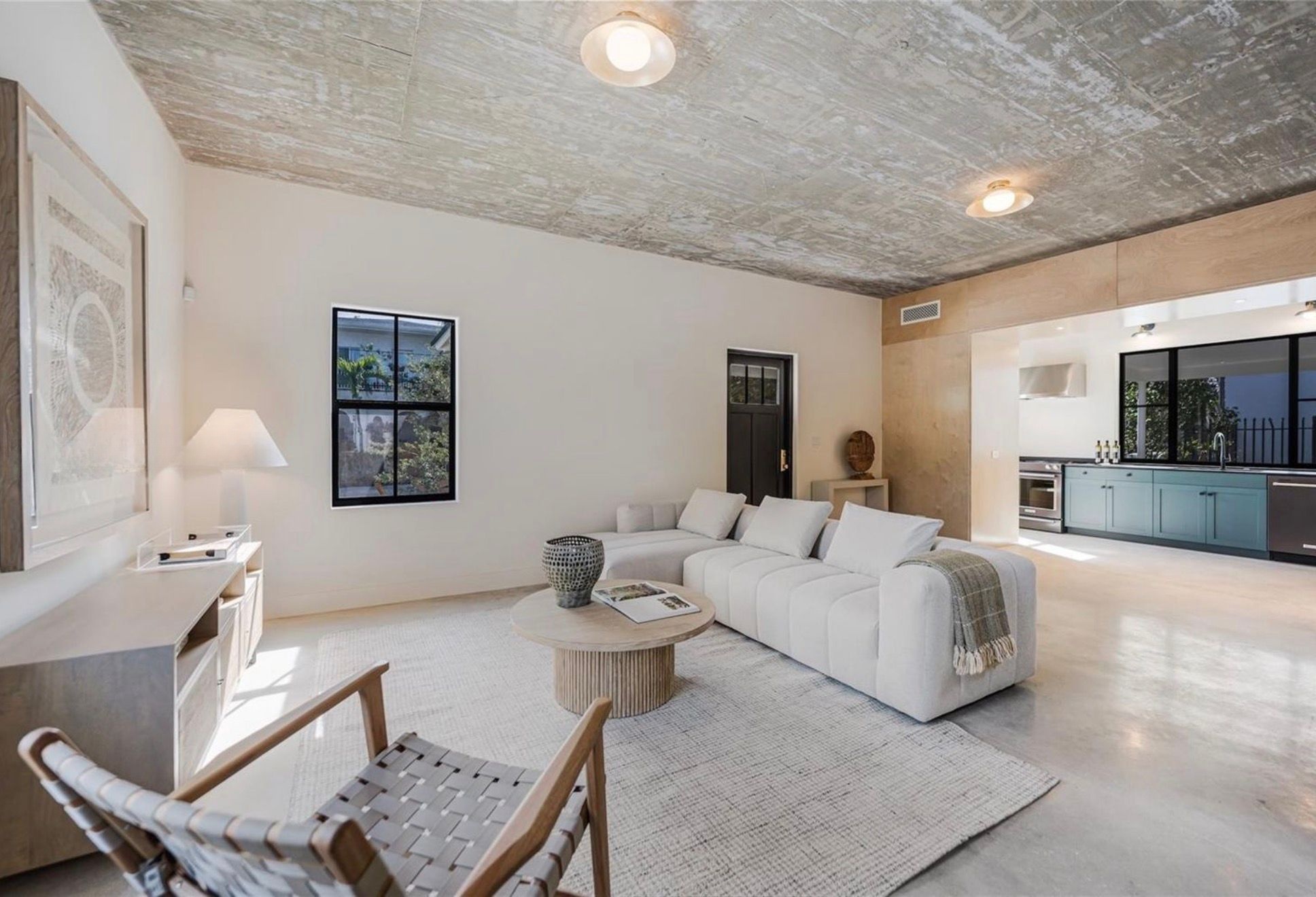 Open living and kitchen under concrete ceiling