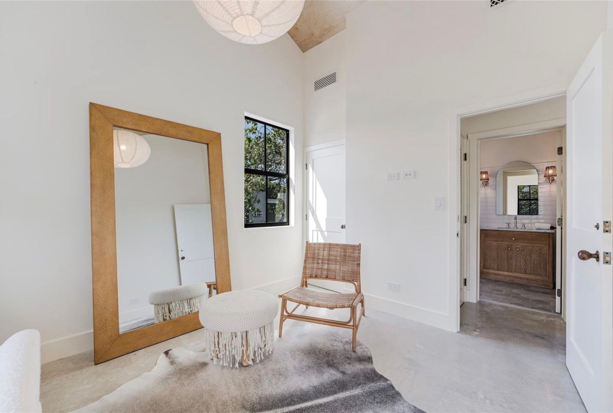 Sitting room with leaning mirror and rattan chair